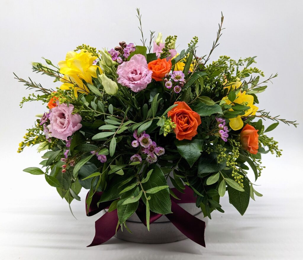 mixed, colourful flowers made in floral foam in a hat box