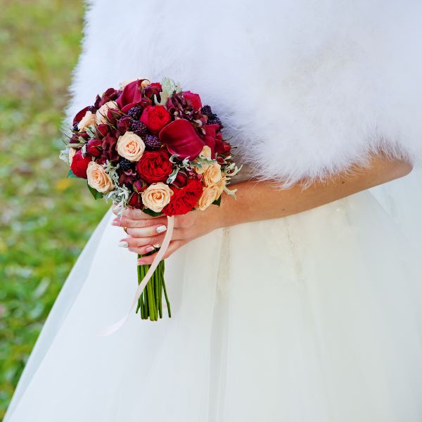 Autumn wedding flowers being held by a bride in a wedding dress