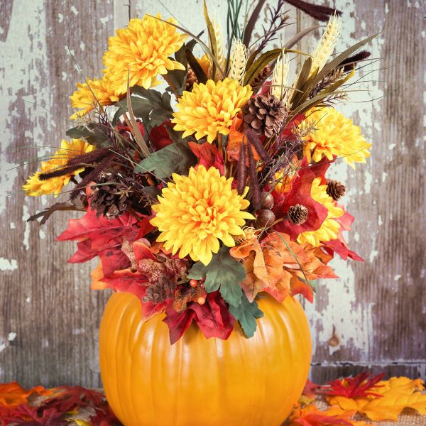 Pumpkin with autumn flowers coming out of the top