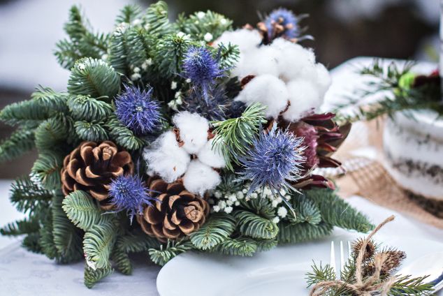 Winter flower bouquet with pine cones and blue, white and green foliage