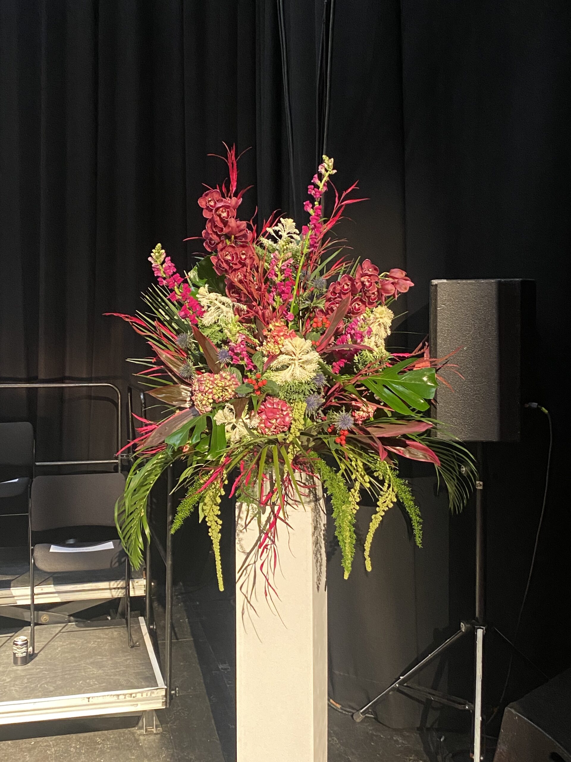 large floral arrangement on a white simple plinth