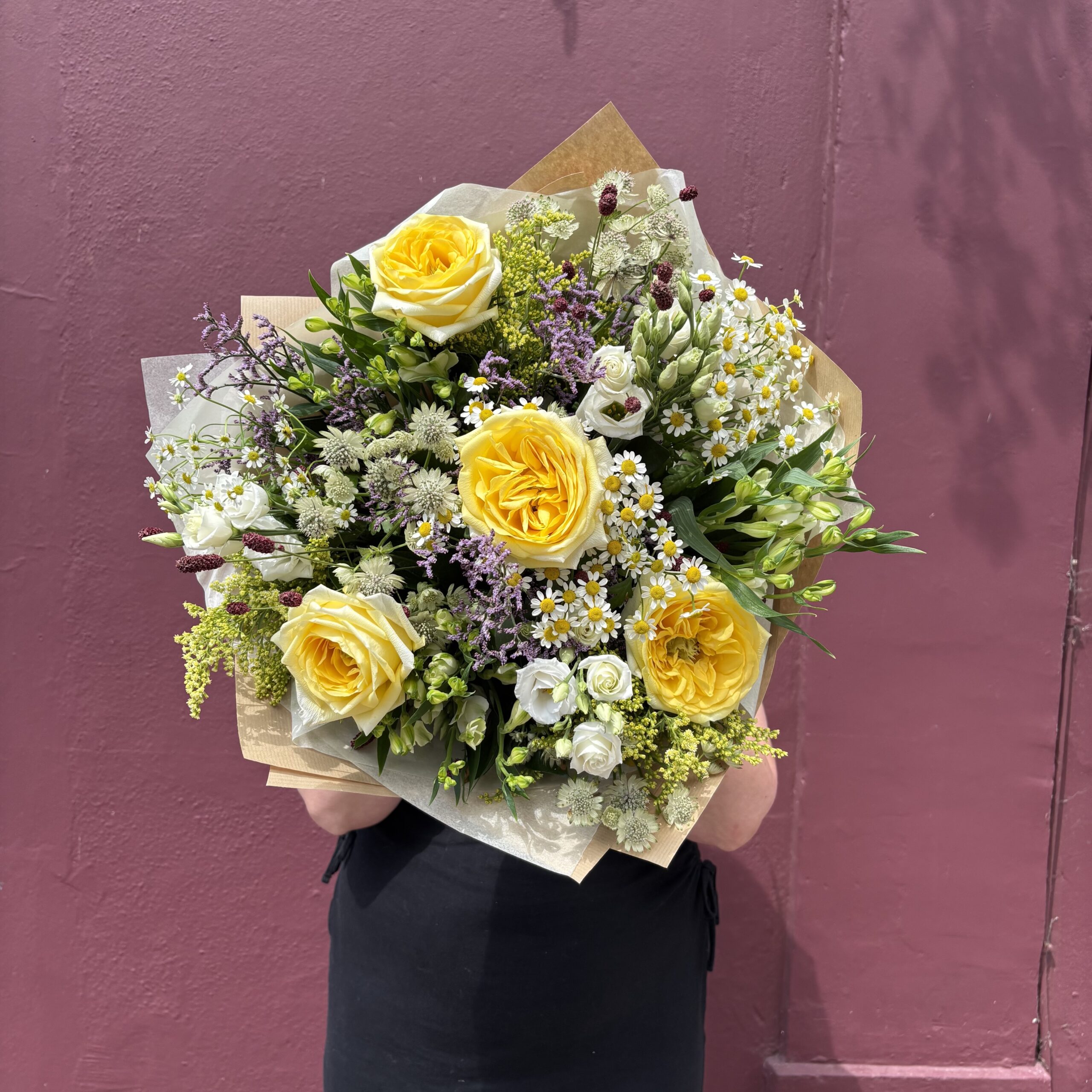 mixed floral bouquet with yellow roses and white and purple filler flowers